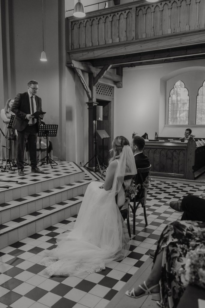Brautpaar lauscht gespannt dem Pastor der freikirchliche Trauung in Wuppertal