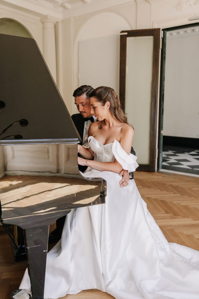 romantisches piano spiel vom brautpaar an ihrer hochzeit, langes weißes fließendes Brautkleid, modern
