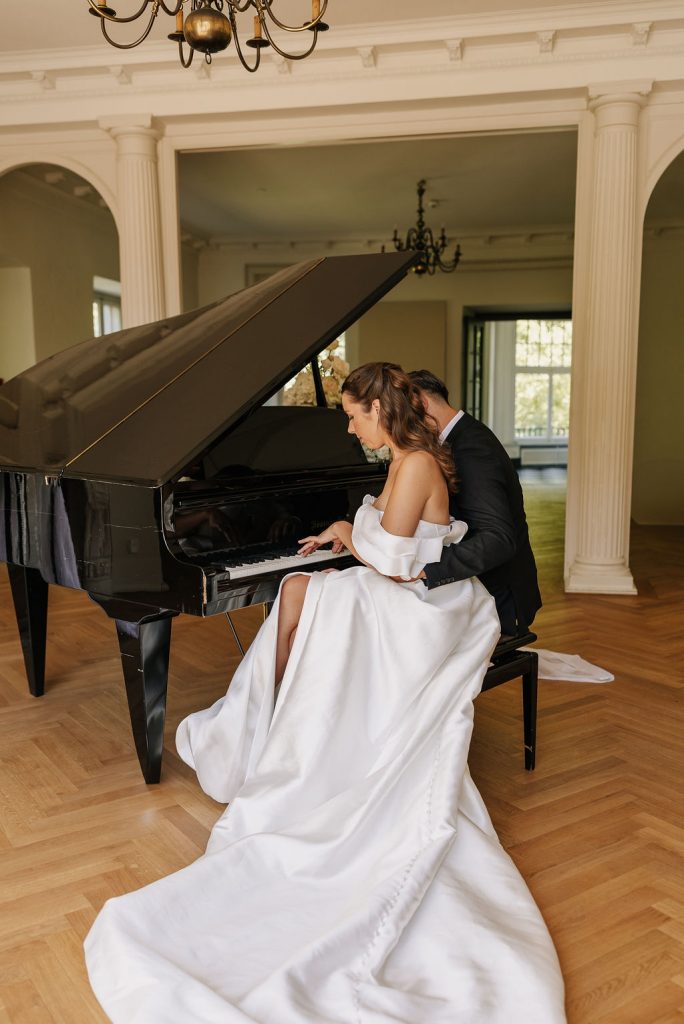 Brautpaar sitzt am Flügel und spielt zusammen ein Lied
