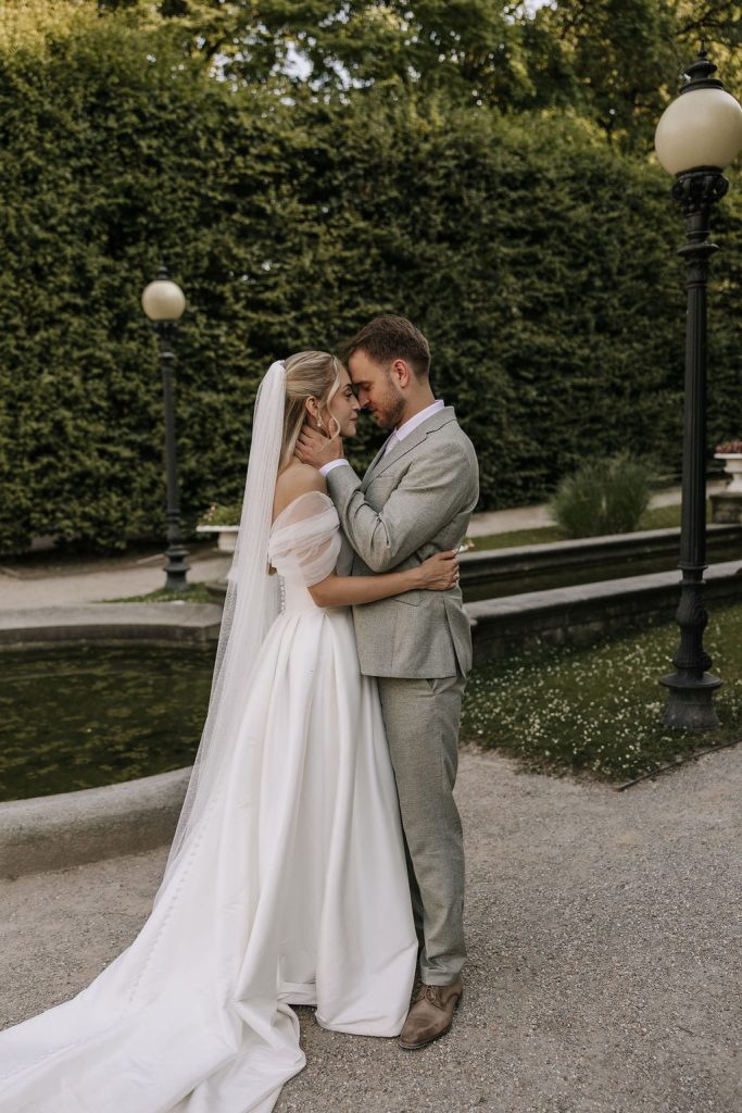 Brautpaar steht in der Flora in Köln (Botanischer Garten) und genießt den Moment vor eine Springbrunnen und viel Grünem Natur Hintergrund