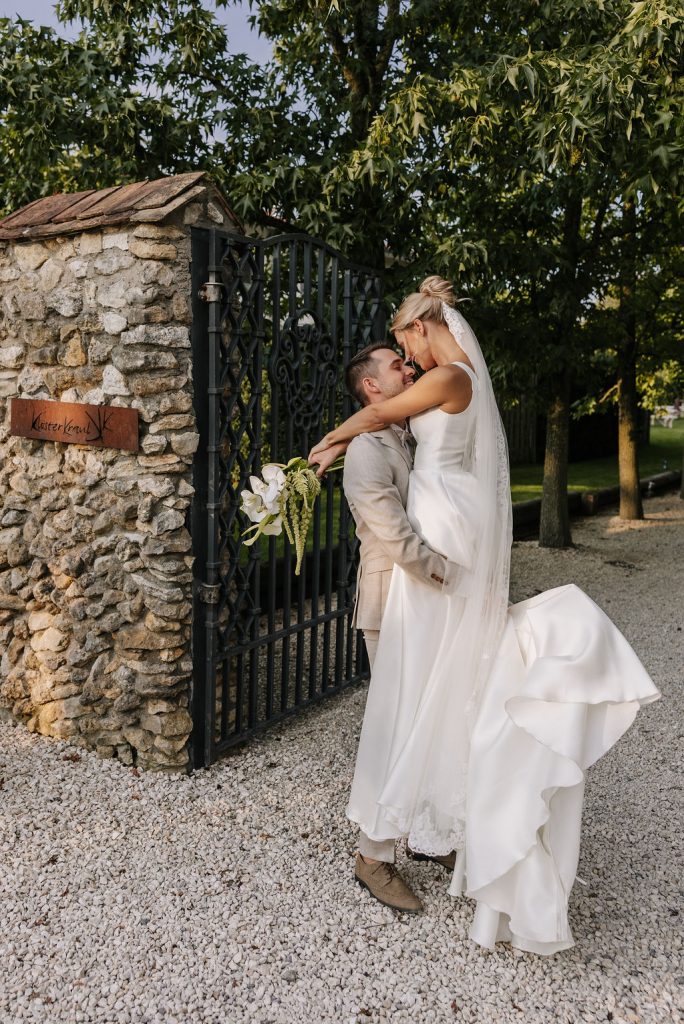 Hebefigur während dem Hochzeitsshooting, Bräutigam hebt Braut hoch und dreht sie romantisch im kreis, Brautkleid wir hochgekickt