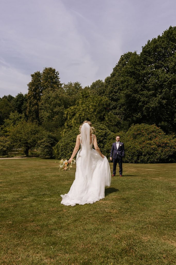 Sommerhochzeit Braut läuft über ein Feld auf ihren Bräutigam zu