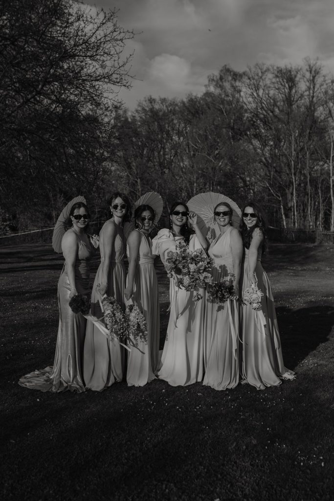 braut und brautjunfdern fotoshooting am and mit Blumensträußen und Sonnenschirmen